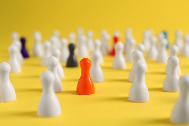 Colorful pawns on yellow background, closeup. Social inclusion concept - Foto, Imagen