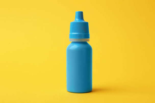 Bottle of medical drops on yellow background - Foto, Imagen