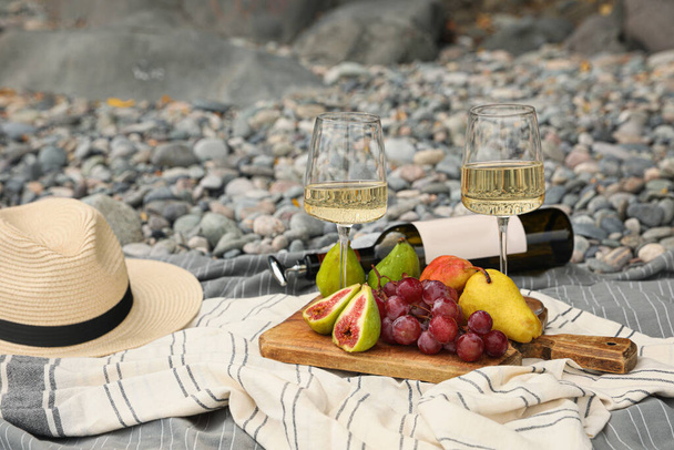 White wine and fresh fruits on picnic blanket outdoors - Foto, Bild