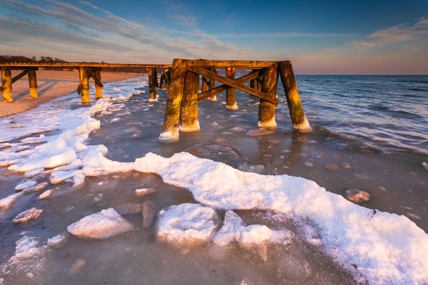 Sabahın erken saatlerinde Sopot sahilindeki küçük iskelenin donmuş elementlerinde. Polonya Sopot 'ta kış manzarası. - Fotoğraf, Görsel