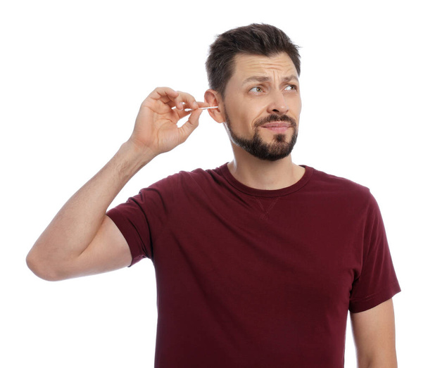 Emotional man cleaning ears on white background - Foto, Bild