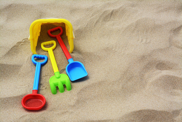 Set of colorful beach toys on sand. Space for text - Φωτογραφία, εικόνα