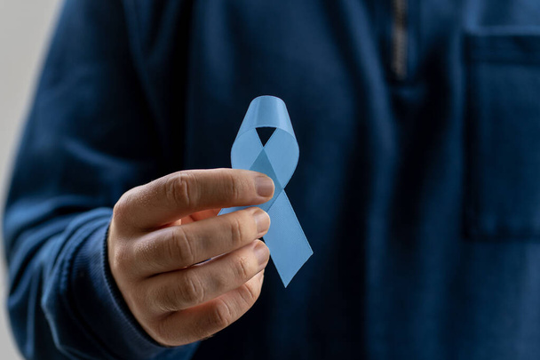 mies, jolla on sininen nauha, joka symboloi eturauhassyöpää ja miesten terveystietoisuuskampanjaa. - Valokuva, kuva
