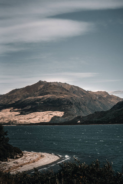 stupendo grande bellissimo lago con acqua blu mosso dal vento vicino alle grandi montagne rocciose sotto un cielo con poche nuvole in un luogo solitario, lago hawea, Nuova Zelanda - concetto di natura - Foto, immagini