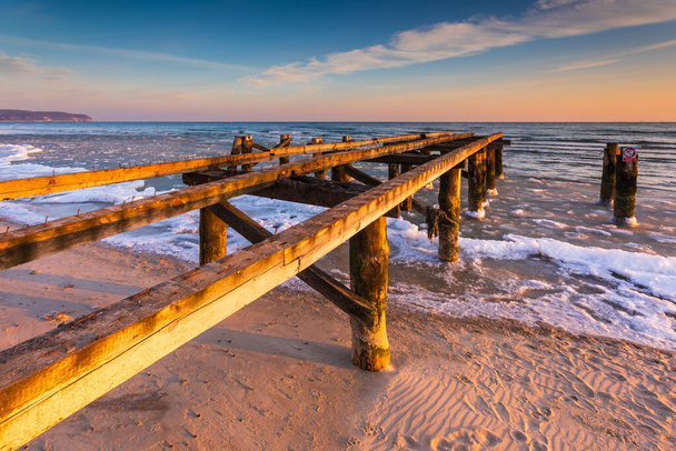 Early morning at frozen elements of small pier at beach in Sopot. Winter landscape in Sopot, Poland. - Photo, Image