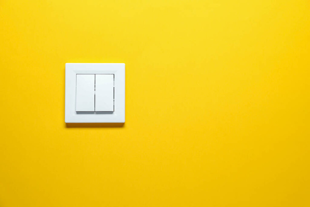 Modern plastic light switch on orange background. Space for text - Foto, imagen
