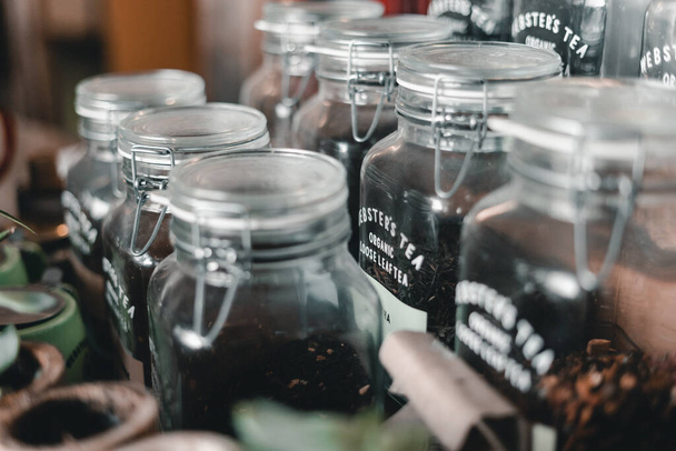 muchos frascos de vidrio pulcros y limpios que contienen té cerrado herméticamente con una tapa de alambre arreglada en un estante, la barra mylk, Nueva Zelanda - Concepto de estilo de vida - Foto, Imagen