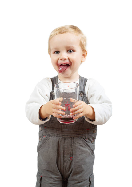 Little boy drinks cherry juice from glass isolated on white - Foto, afbeelding