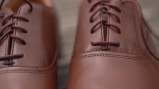 Zapatos de hombre de cuero marrón de pie en un piso de madera. Imágenes FullHD de alta calidad - Imágenes, Vídeo