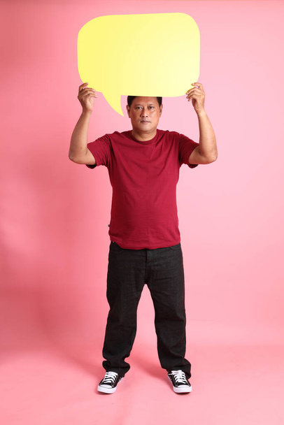 Der erwachsene, übergewichtige asiatische Mann der 40er Jahre steht auf dem rosa Hintergrund. - Foto, Bild