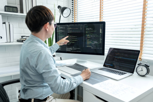 Чоловік-програміст вказує на екран і програмування для розробки програмного додатку і веб-сайту корпоративного під час роботи з перевіркою програмного коду і зневаджування на декількох екранах в сучасному програмному офісі
. - Фото, зображення