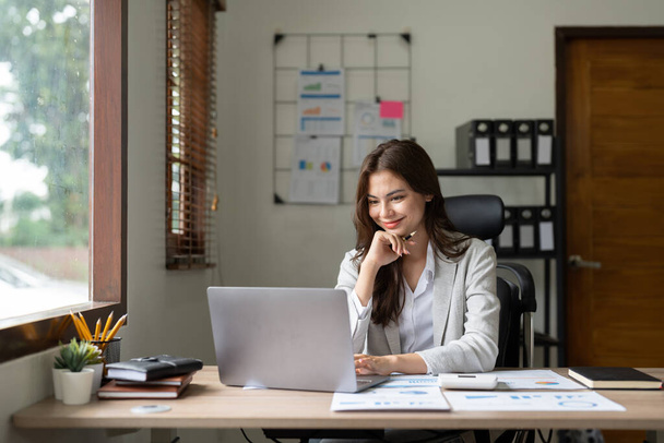 Женщина-бухгалтер с помощью калькулятора и компьютера в офисе, финансов и бухгалтерского учета концепции - Фото, изображение