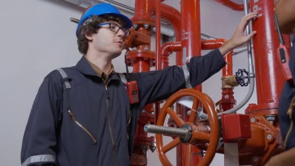 Young woman and man engineer check and examining pipeline and discussion in the factory, mechanic or technician inspector plumber valve and talking together, industrial and maintenance concept. - Filmagem, Vídeo