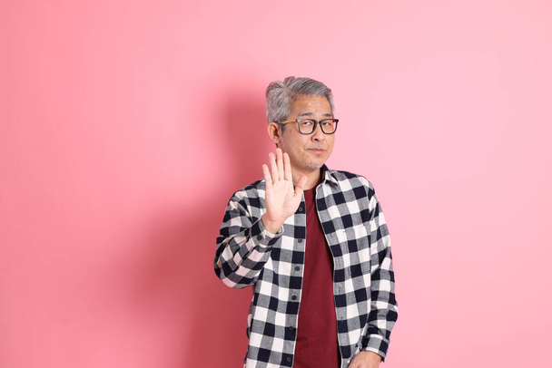 The 40s adult Asian man stnading on the pink background with casual clothes. - Valokuva, kuva