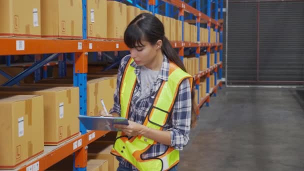Young man and woman worker check stock and inspection with document on clipboard in the warehouse at factory, worker working at storehouse, logistic and cargo, shipping and distribution. - Felvétel, videó