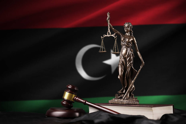 Bandera de Libia con estatua de la señora justicia, constitución y juez martillo en negro cortina. Concepto de juicio y castigo - Foto, imagen