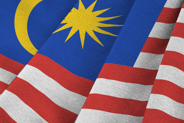 Die malaysische Flagge mit großen Falten weht in Großaufnahme unter dem Studiolicht drinnen. Die offiziellen Symbole und Farben in Stoffbanner - Foto, Bild