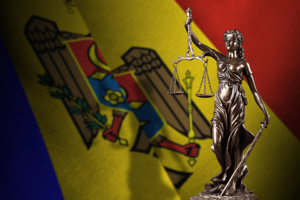 Bandera de Moldavia con estatua de dama de la justicia y escalas judiciales en cuarto oscuro. Concepto de juicio y castigo, antecedentes de los temas del jurado - Foto, imagen