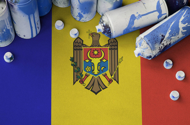 Σημαία Μολδαβίας και λίγα χρησιμοποιούνται σπρέι αεροζόλ δοχεία για γκράφιτι ζωγραφική. Τέχνη του δρόμου έννοια του πολιτισμού, βανδαλισμός προβλήματα - Φωτογραφία, εικόνα