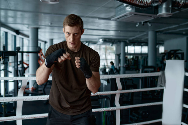 Confidence man boxer κάνει αθλητισμό προπόνηση πυγμαχία άσκηση punching αέρα στην πλευρά του δακτυλίου άποψη αργή κίνηση - Φωτογραφία, εικόνα