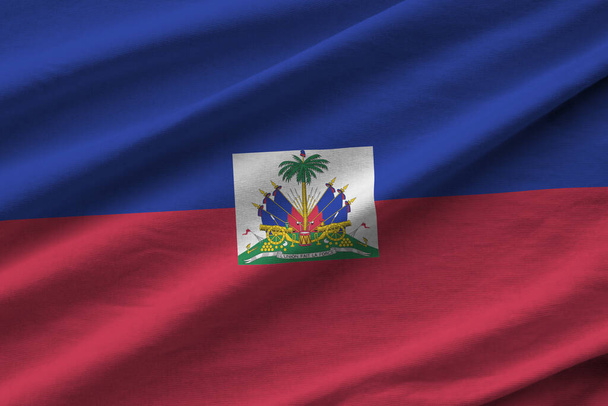 Bandera de Haití con grandes pliegues ondeando de cerca bajo la luz del estudio en el interior. Los símbolos oficiales y los colores en banner de tela - Foto, imagen