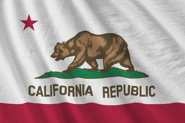 Kalifornijska flaga stanowa z dużymi fałdami machająca z bliska pod światłem studyjnym wewnątrz. Oficjalne symbole i kolory w banerze tkaniny - Zdjęcie, obraz
