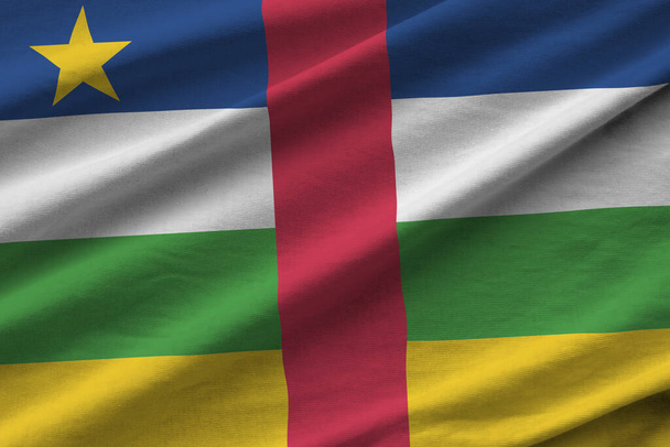 Bandera de la República Centroafricana con grandes pliegues ondeando de cerca bajo la luz del estudio en el interior. Los símbolos oficiales y los colores en banner de tela - Foto, Imagen