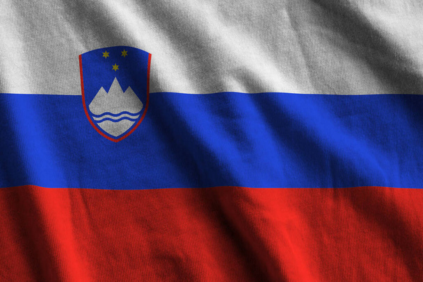Slovenië vlag met grote plooien zwaaien close-up onder de studio licht binnen. De officiële symbolen en kleuren in stof banner - Foto, afbeelding