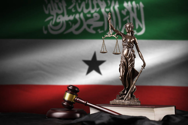 Somaliland flag with statue of lady justice, constitution and judge hammer on black drapery. Concept of judgement and punishment - Photo, Image