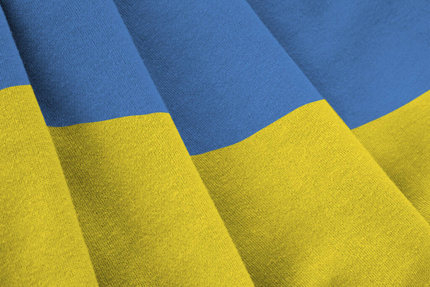 Bandera de Ucrania con grandes pliegues ondeando de cerca bajo la luz del estudio en el interior. Los símbolos oficiales y los colores en banner de tela - Foto, Imagen