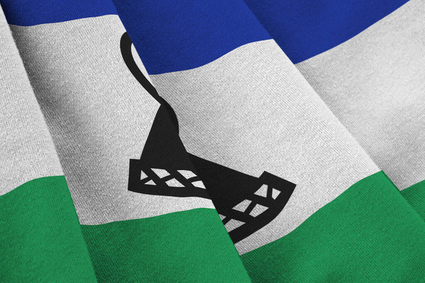 Lesotho zászló nagy redők integetett szoros alatt a stúdió fény beltérben. A hivatalos szimbólumok és színek szövet banner - Fotó, kép