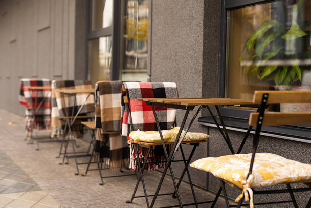 comfortabele stoelen in een straat cafe met dekens. - Foto, afbeelding