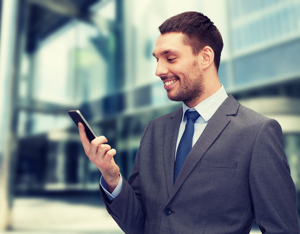 young smiling businessman with smartphone - Foto, afbeelding