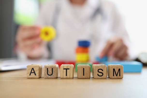 Крупним планом слово аутизм зібраний з дерев'яними кубиками літер. Розлад розвитку, труднощі в соціальній взаємодії та спілкуванні. Медицина та концепція охорони здоров'я
 - Фото, зображення