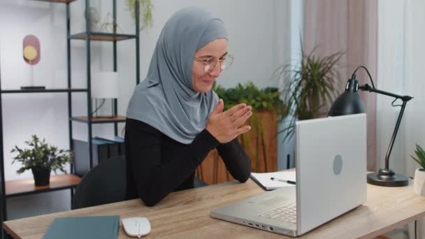 Sneaky astúcia jovem mulher de negócios muçulmano vestindo lenço de cabeça hijab com rosto complicado gesticulando e planejando plano maligno, pensando sobre ideia vilã desonesto. Freelancer menina no espaço de trabalho do escritório em casa - Filmagem, Vídeo