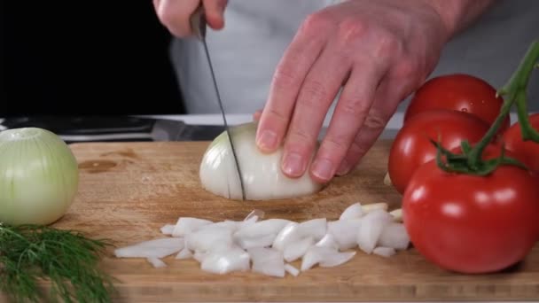 picando cebollas, cocinero picando cebollas con un cuchillo, tabla de cortar - Imágenes, Vídeo
