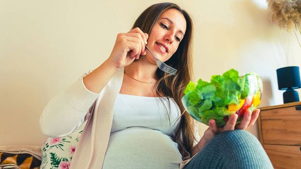 Pregnancy eating healthy salad. Happy pregnant woman eating nutrition food. People lifestyle food concept - Photo, image