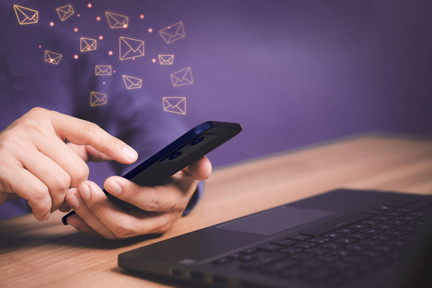Email Marketing and Newsletters, Technology and lifestyle concepts. Man's hand using smartphone or mobile phone and sending online message with email icon. - Photo, Image