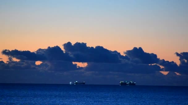 Bir tahıl taşıyıcı tanker, şafak vakti yağan yağmurlar ve büyük kara bulutlarla birlikte denizin ufuk çizgisinin çok uzağındadır. Deniz manzarası, deniz manzarası. Doğal arkaplan - Video, Çekim
