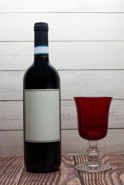 Bottle of red wine with blank label and red glass - Φωτογραφία, εικόνα