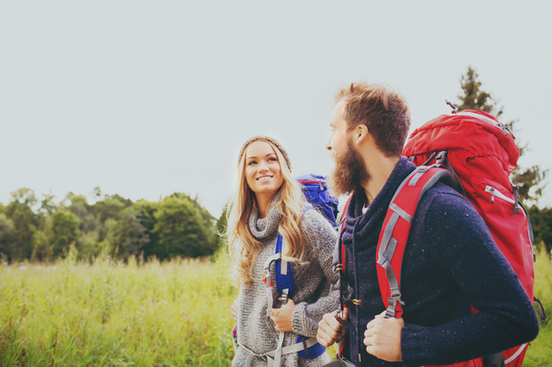 smiling couple with backpacks hiking - 写真・画像
