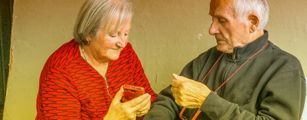 Akıllı telefonun nasıl kullanılacağını bulmaya çalışan yaşlı bir çift. - Fotoğraf, Görsel