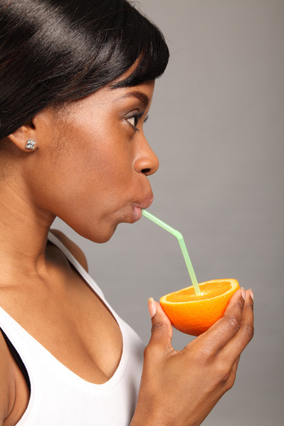 Beautiful african american woman with orange fruit - Foto, Imagen