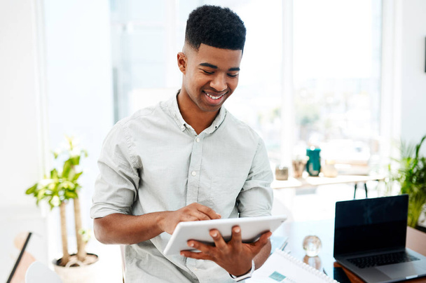 De slimmere weg naar succes nemen. een jonge zakenman met een digitale tablet in een modern kantoor - Foto, afbeelding
