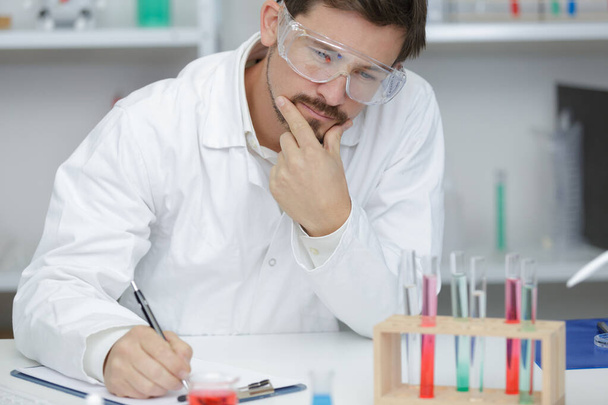 research worker doing experiments with chemical liquid at laboratory - Foto, Bild