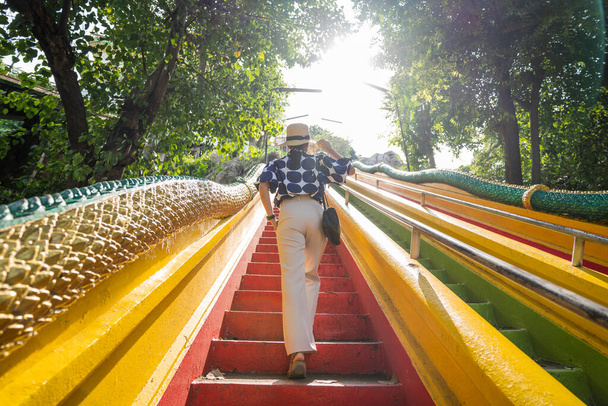 Asiatische Touristinnen gehen bunte Treppen am Wat Tham Seua, Kanchanaburi, Thailand hinauf. - Foto, Bild