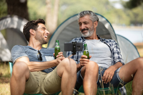 friends relaxing at campsite after day hiking - Photo, image