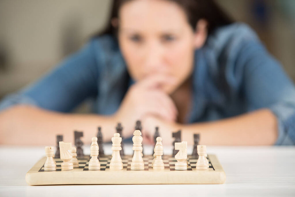 woman studying the next chess move - Foto, afbeelding