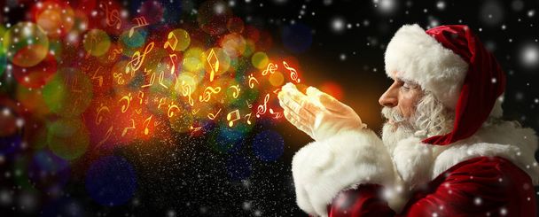 Portrait du Père Noël jouant avec la neige et des signes de note de musique sur fond sombre - Photo, image