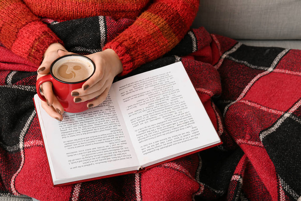 Woman with cup of coffee reading book, closeup - Foto, imagen